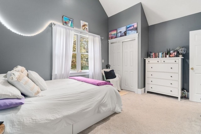 carpeted bedroom featuring vaulted ceiling and a closet