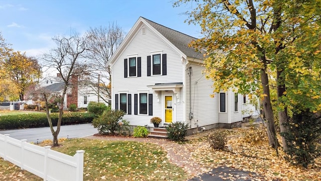 traditional-style home featuring fence and a front yard