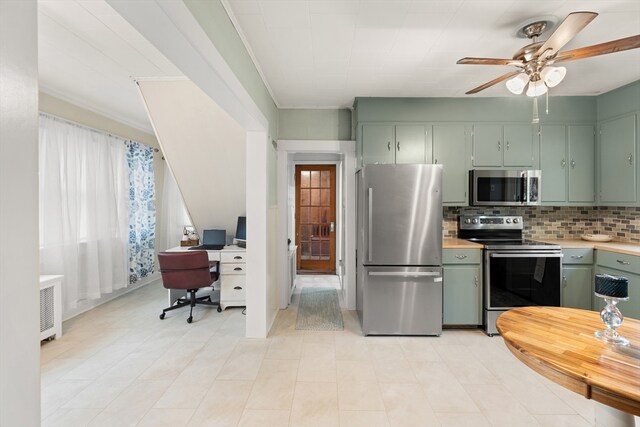 kitchen with a ceiling fan, backsplash, appliances with stainless steel finishes, light countertops, and green cabinets