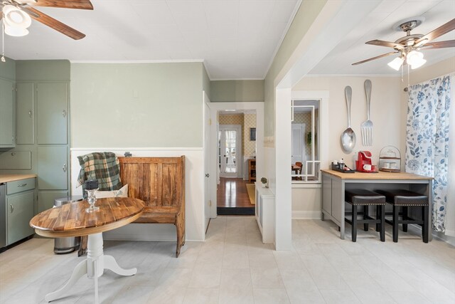 sitting room featuring ornamental molding, a ceiling fan, and light tile patterned flooring