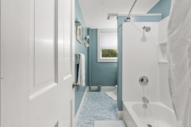 full bath featuring tile patterned floors, baseboards, shower / bath combo, and toilet