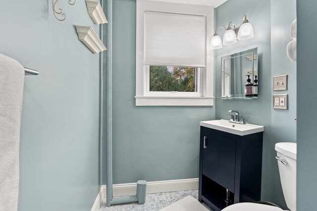 bathroom with vanity, baseboards, tile patterned floors, and toilet