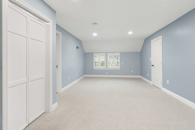spare room featuring baseboards, light carpet, vaulted ceiling, and recessed lighting