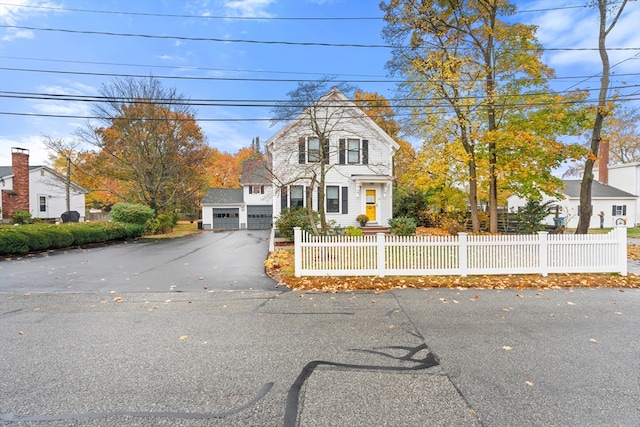 view of front of home featuring an attached garage, a fenced front yard, and driveway