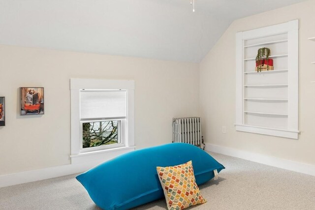 bedroom featuring baseboards, lofted ceiling, radiator heating unit, and carpet