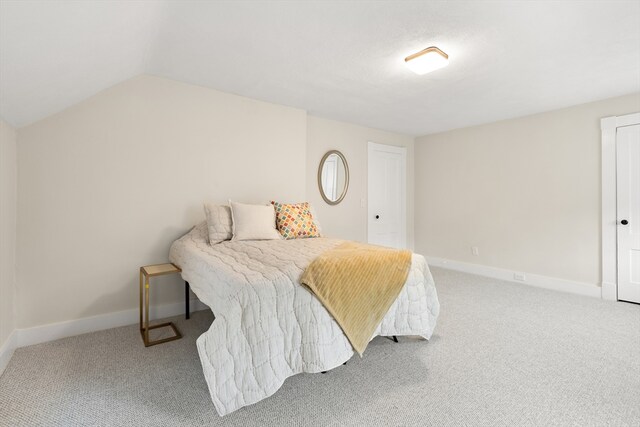 bedroom with baseboards, carpet flooring, and lofted ceiling