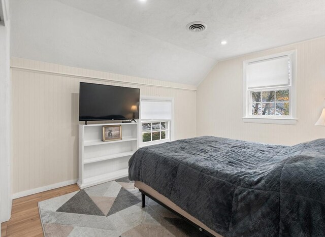 bedroom featuring visible vents, lofted ceiling, wood finished floors, baseboards, and recessed lighting