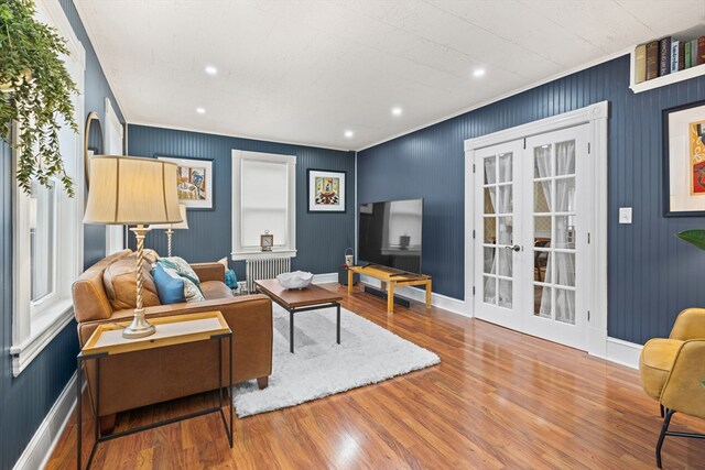 living room featuring radiator, baseboards, recessed lighting, and wood finished floors