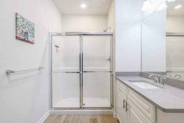 bathroom with vanity, wood-type flooring, and a shower with shower door