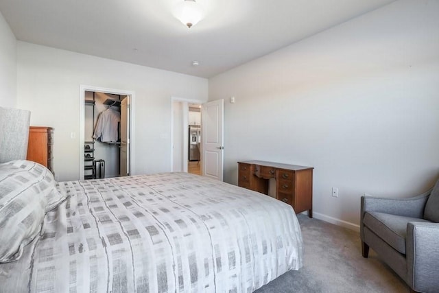 bedroom with light carpet, a spacious closet, and a closet