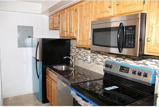 kitchen with backsplash, sink, light tile floors, and stainless steel appliances