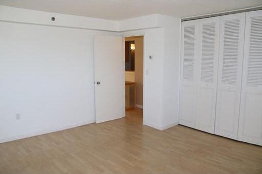 unfurnished bedroom with a closet and light wood-type flooring