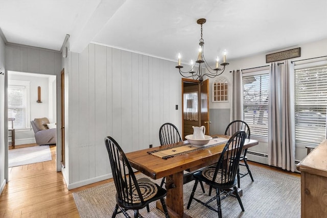 dining room featuring a notable chandelier, light wood-style flooring, and baseboards