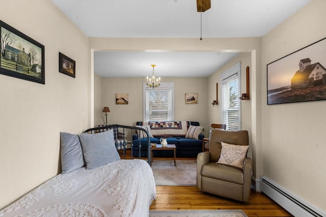 bedroom featuring hardwood / wood-style floors, an inviting chandelier, and a baseboard radiator