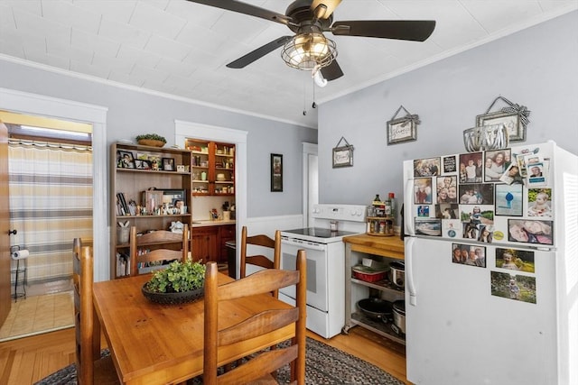 dining room with wood finished floors, a ceiling fan, and ornamental molding