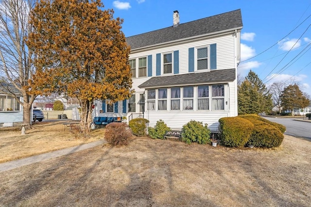 view of front of property with roof with shingles and a chimney