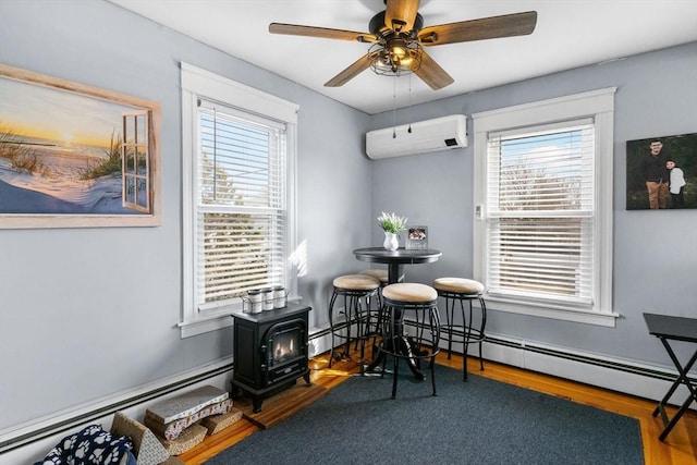 dining space featuring a baseboard radiator, plenty of natural light, ceiling fan, and a wall unit AC