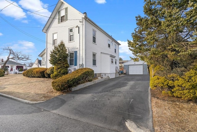 view of property exterior with a detached garage and an outdoor structure