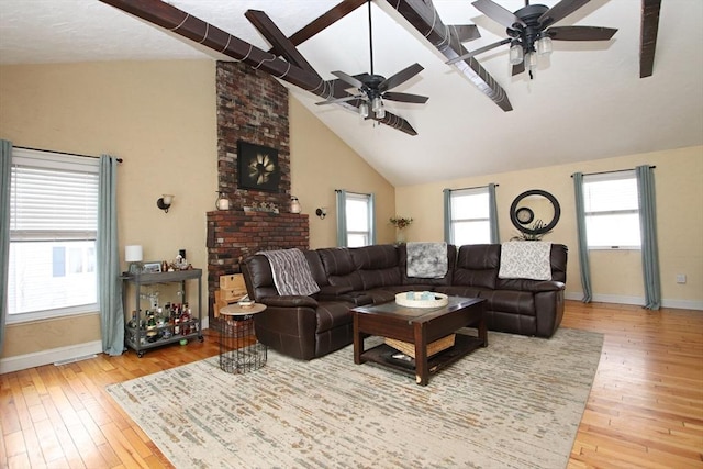 living room with hardwood / wood-style flooring, ceiling fan, high vaulted ceiling, and a fireplace