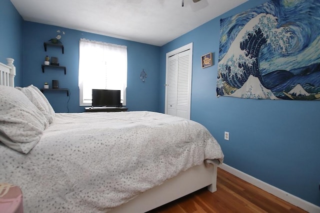 bedroom with ceiling fan, dark hardwood / wood-style flooring, and a closet