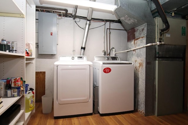 laundry room featuring independent washer and dryer, electric panel, and light hardwood / wood-style floors