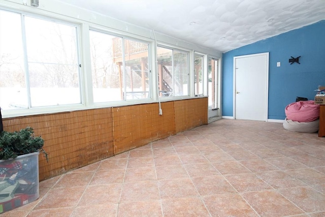 unfurnished sunroom featuring vaulted ceiling