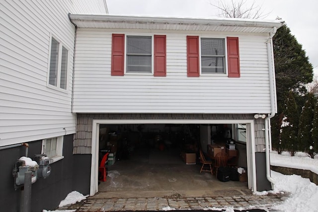 view of snowy exterior featuring a garage