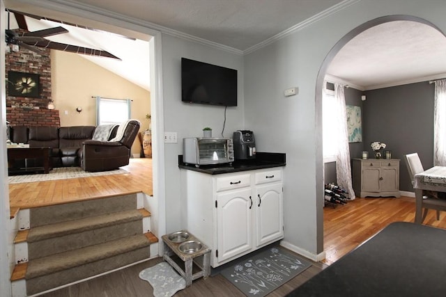 interior space with crown molding, lofted ceiling, and hardwood / wood-style floors