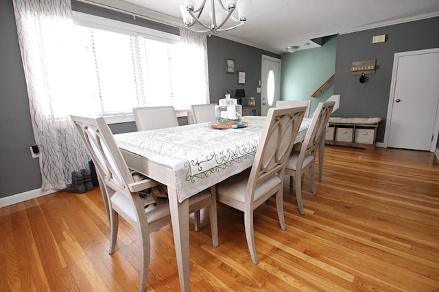 dining space with a notable chandelier and light hardwood / wood-style flooring