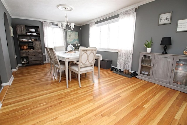 dining area featuring ornamental molding, a chandelier, and light hardwood / wood-style flooring