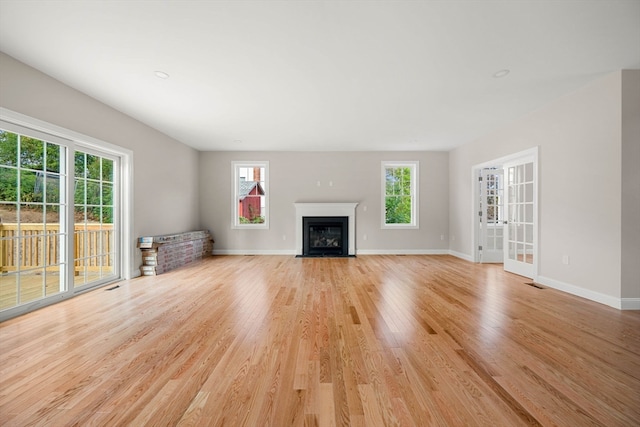 unfurnished living room with light hardwood / wood-style flooring and a wealth of natural light