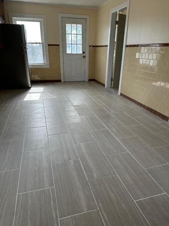 entryway with tile walls and wainscoting