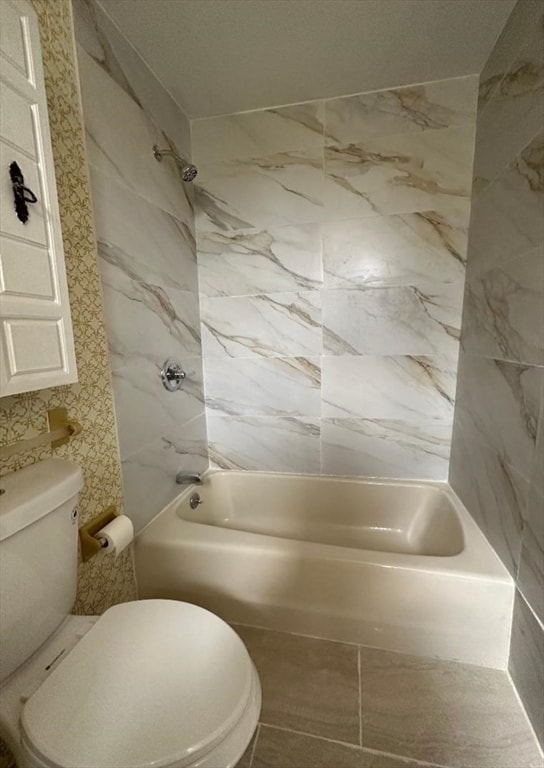 bathroom featuring tiled shower / bath and toilet