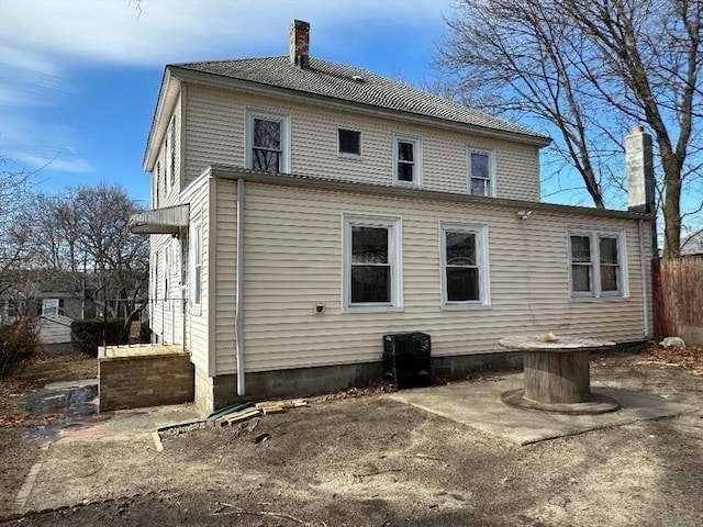 back of house featuring a chimney