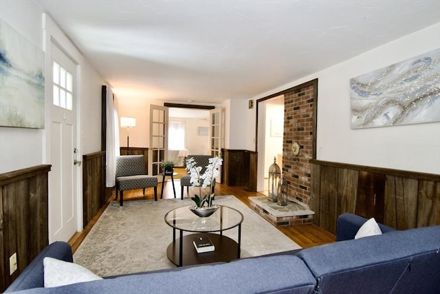 living area featuring a wainscoted wall, wood walls, and wood finished floors