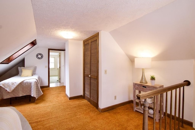 bedroom featuring carpet, a closet, vaulted ceiling, a textured ceiling, and baseboards