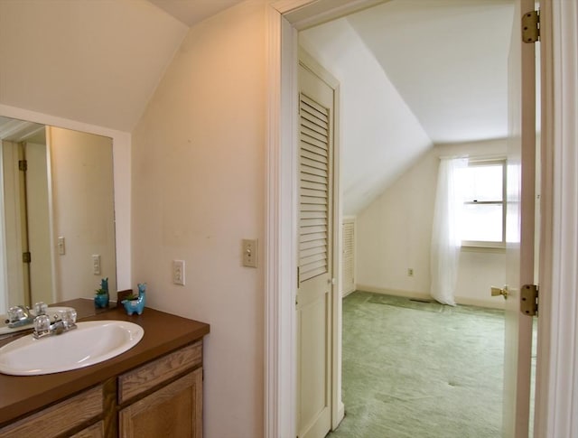 bathroom with vaulted ceiling and vanity