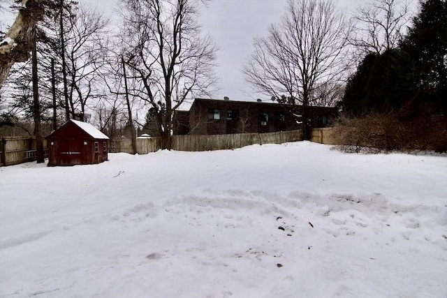 snowy yard featuring fence