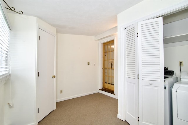 interior space featuring baseboards, washer and clothes dryer, and light colored carpet