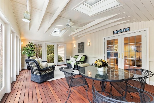 sunroom / solarium featuring a ceiling fan, lofted ceiling with skylight, and french doors