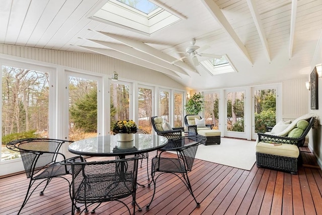 sunroom / solarium with lofted ceiling with skylight, a ceiling fan, and a wealth of natural light