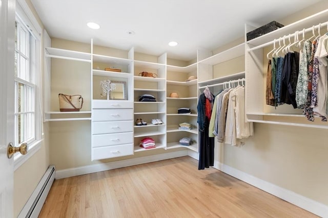 spacious closet featuring baseboard heating and wood finished floors