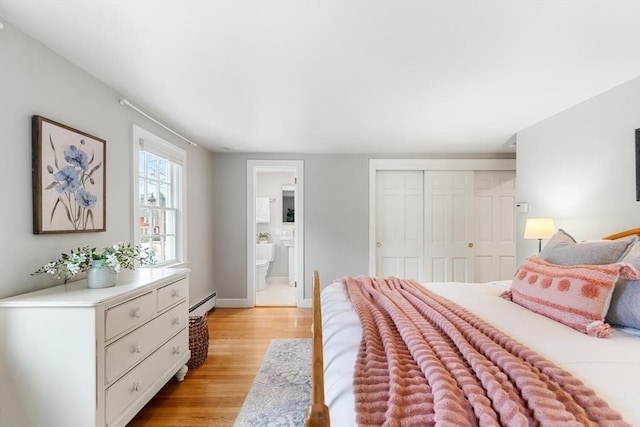 bedroom with light wood-style flooring, ensuite bath, a closet, baseboards, and baseboard heating