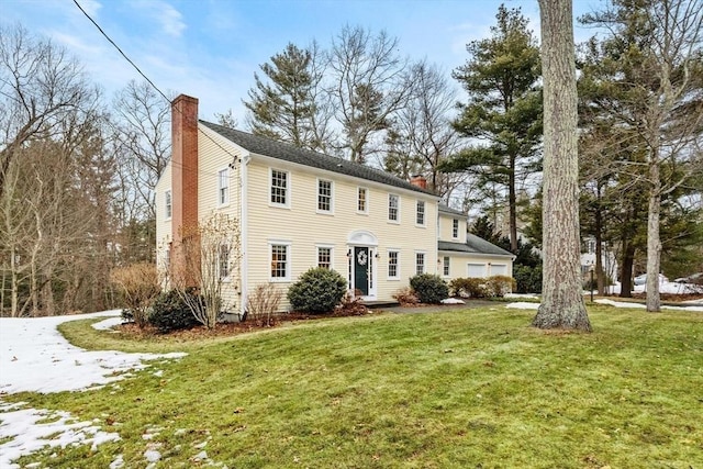 colonial inspired home with a front lawn and a chimney