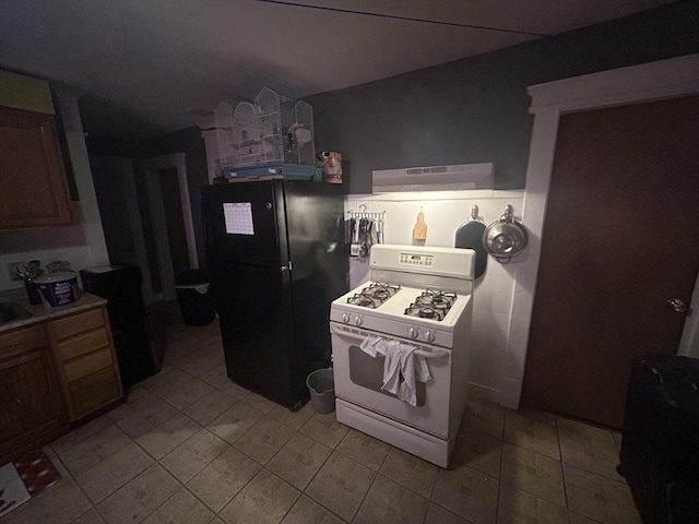 kitchen featuring black fridge and white range with gas cooktop