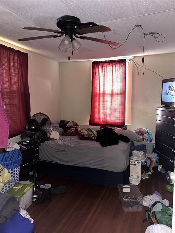 bedroom featuring wood-type flooring, a textured ceiling, and ceiling fan