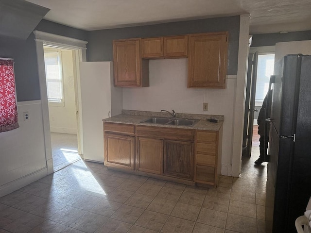 kitchen with black refrigerator, plenty of natural light, and sink