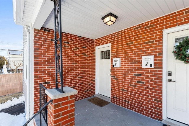 doorway to property featuring brick siding