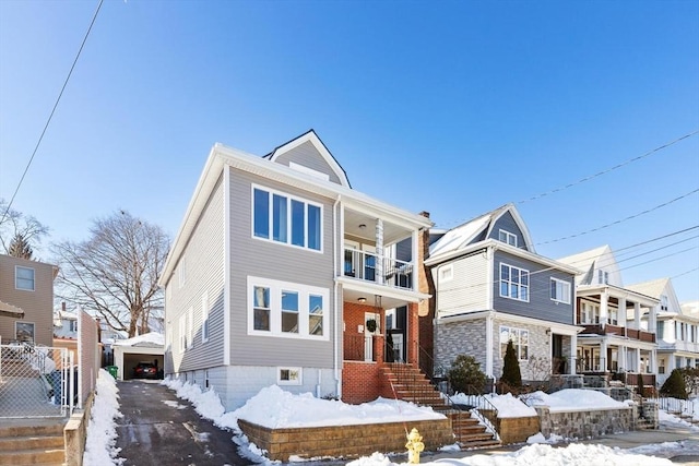 view of front of house with a detached garage, a residential view, and a balcony