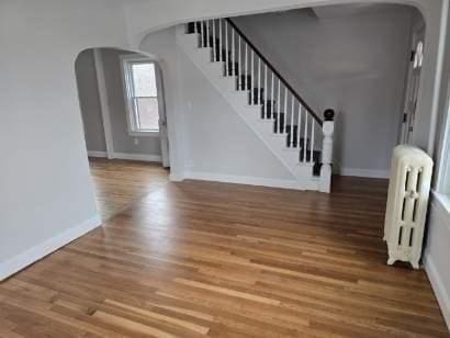 interior space with hardwood / wood-style floors and radiator heating unit